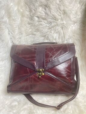 M.C textured leather patchwork like stitched accent burgundy leather bag .